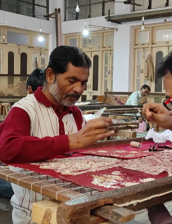 Master embroidery artisan performing intricate hand Maggam and zardozi needlework